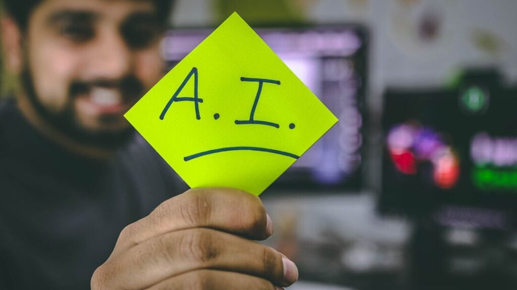 An IT worker holds up a post-it note with "A.I." written on it.
